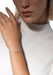 Messika Baby Move 18K White Gold Diamond Bracelet shown on model's wrist wearing a white blouse.