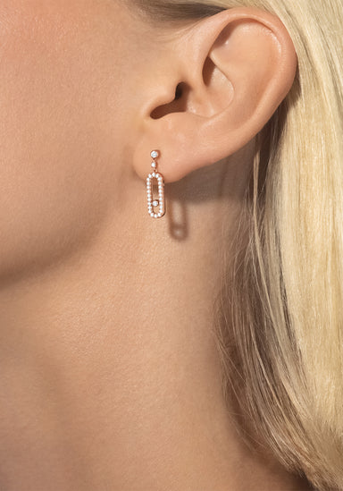 Closeup of blonde model wearing a single Messika Move Uno Stud 18KRG Diamond Dangle Earring