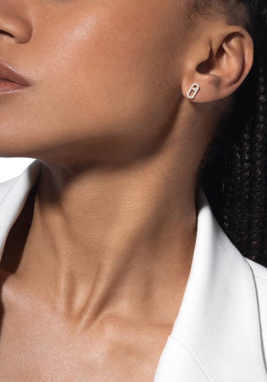 Closeup of Black model wearing a single Messika Move Uno 18K Gold Diamond Earring and white blazer