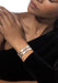 Closeup of a Black model wearing two Messika Move Noa 18K White Gold Pavé Diamond Bangles on wrist