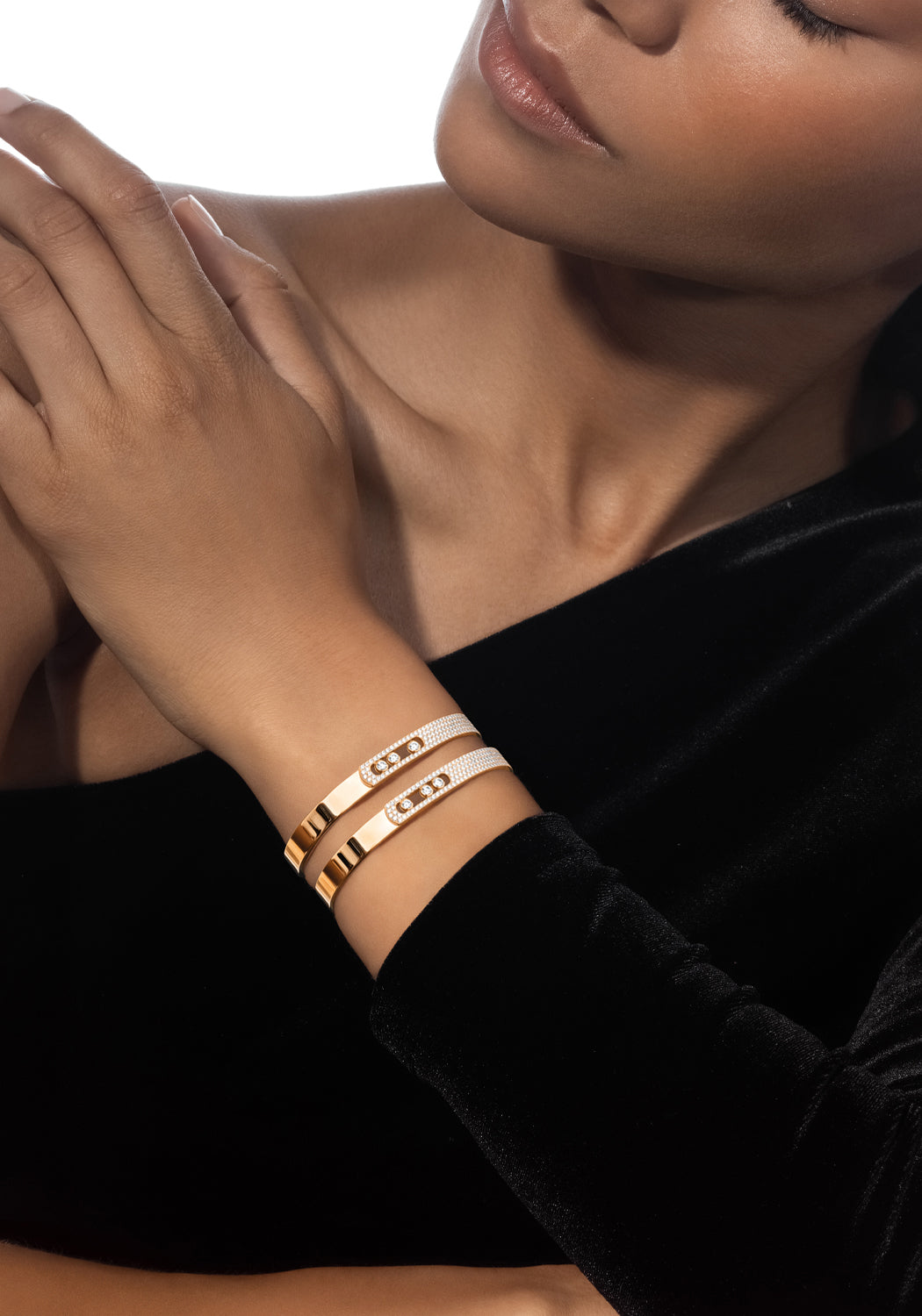 Closeup of a Black model wearing two Messika Move Noa 18K Yellow Gold Pavé Diamond Bangles on wrist