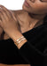 Closeup of a Black model wearing two Messika Move Noa 18K Yellow Gold Pavé Diamond Bangles on wrist