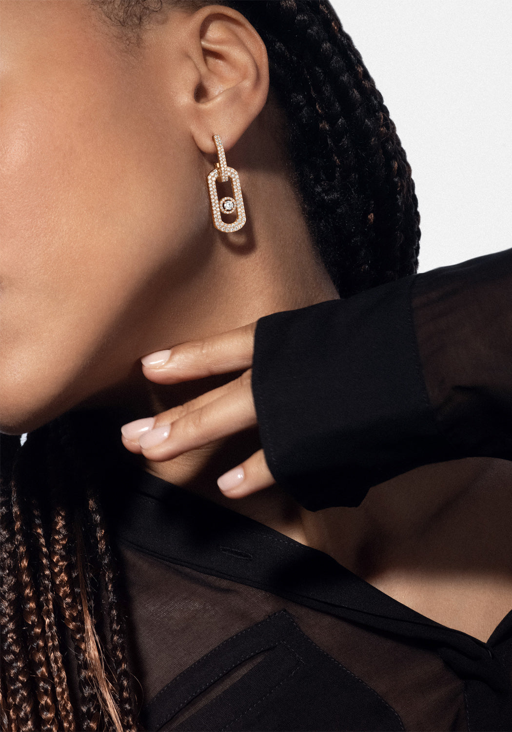 Closeup of model wearing a Messika So Move XL 18KYG Pavé Diamond Pendant Earrings and black outfit