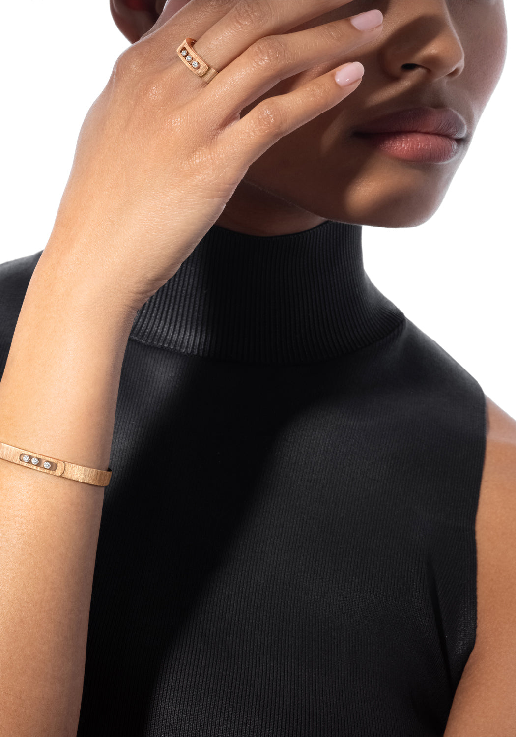 Black model covering face wearing Messika Move Noa Ciselé 18KRG Diamond Bangle Bracelet and Ring