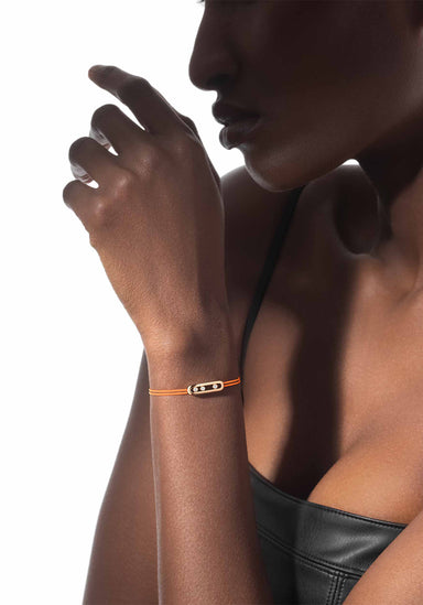 Closeup of Black model wearing a Messika Care(s) Orange Cord Diamond Bracelet and leather top