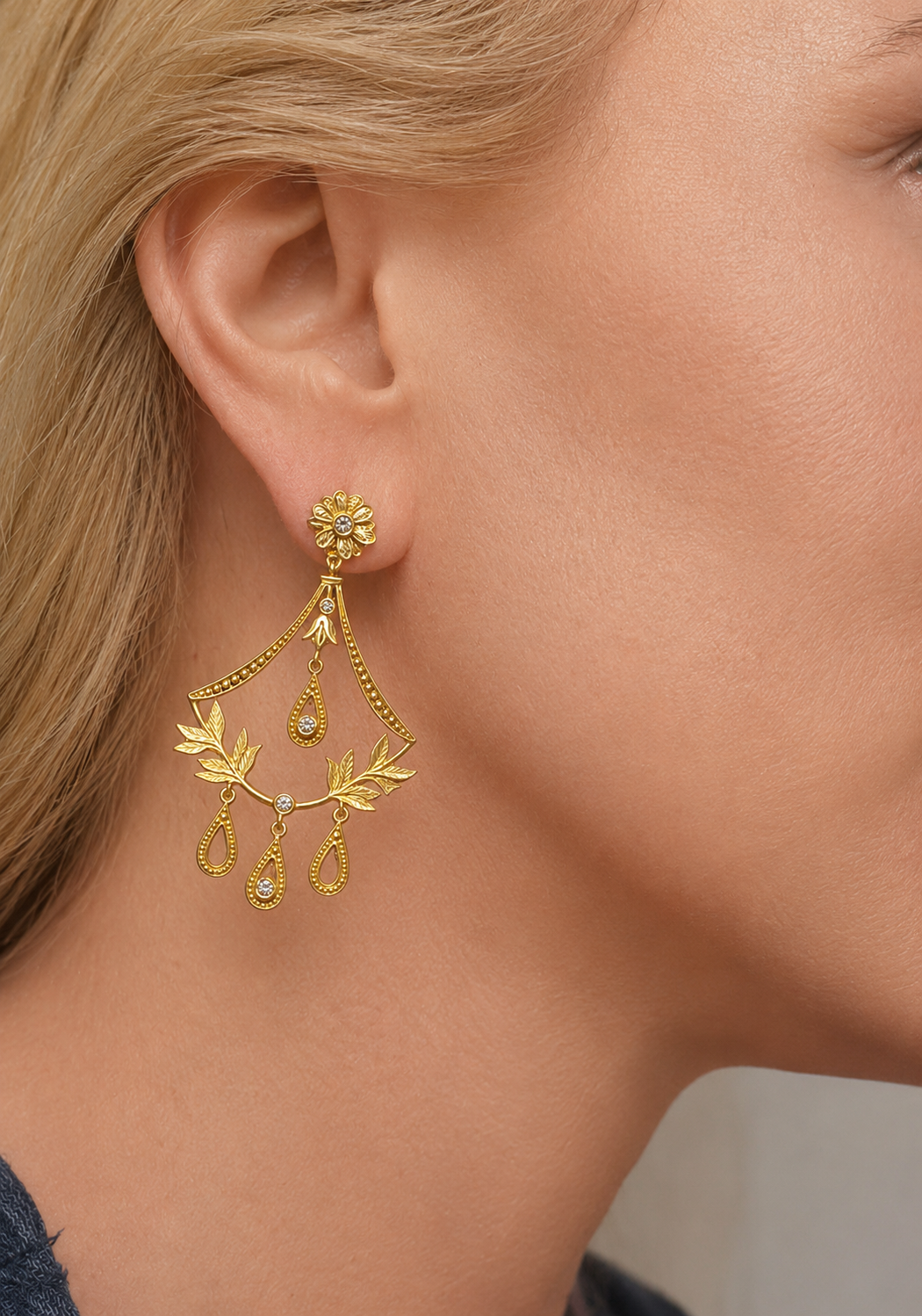 Blonde Woman wearing ornate gold scroll baroque style chandelier earring.