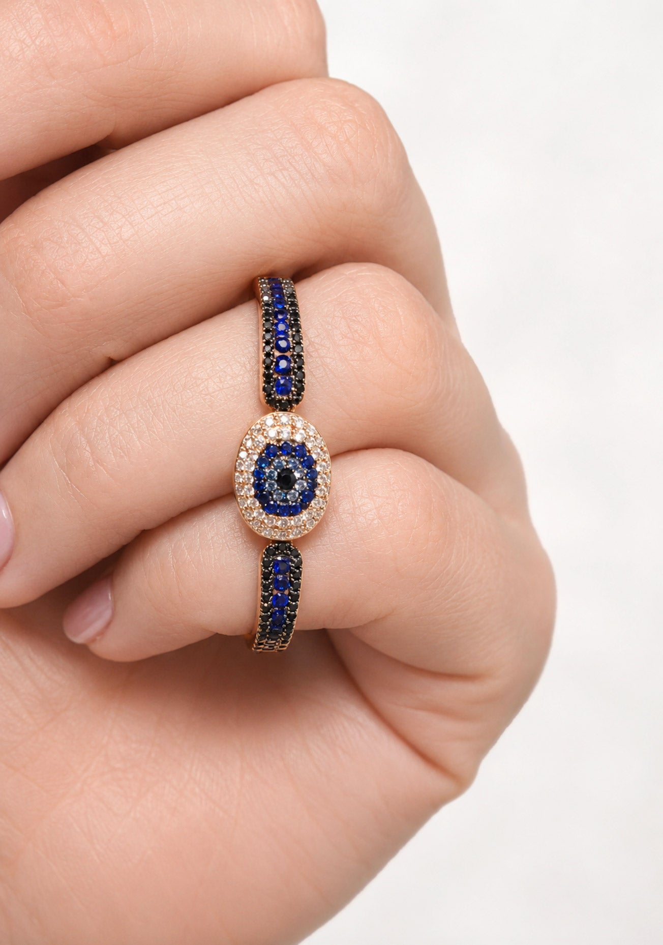 Female hand wearing a blue sapphire & diamond double finger ring. Osterjewelers.com