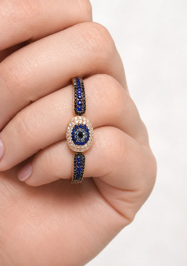 Female hand wearing a blue sapphire & diamond double finger ring. Osterjewelers.com