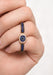 Female hand wearing a blue sapphire & diamond double finger ring. Osterjewelers.com