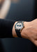 The Angelus Chronographe Tachymètre Steel Grey on a man's wrist wearing a dark long sleeved shirt