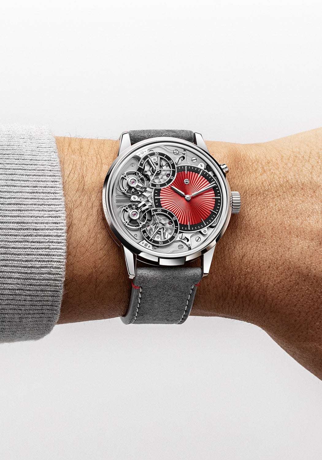 Armin Strom Mirrored Force Resonance Red luxury watch is shown on a man's wrist with a grey sweater