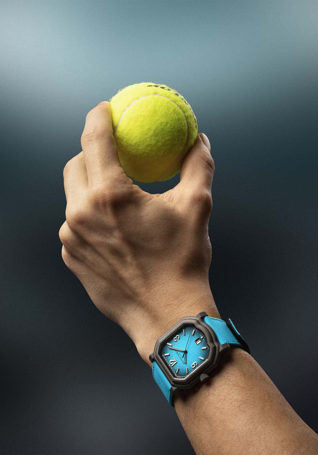 The Gerald Charles Maestro GC Sport Tennis Light Turquoise on a man's wrist holding a tennis ball