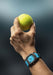 The Gerald Charles Maestro GC Sport Tennis Light Turquoise on a man's wrist holding a tennis ball