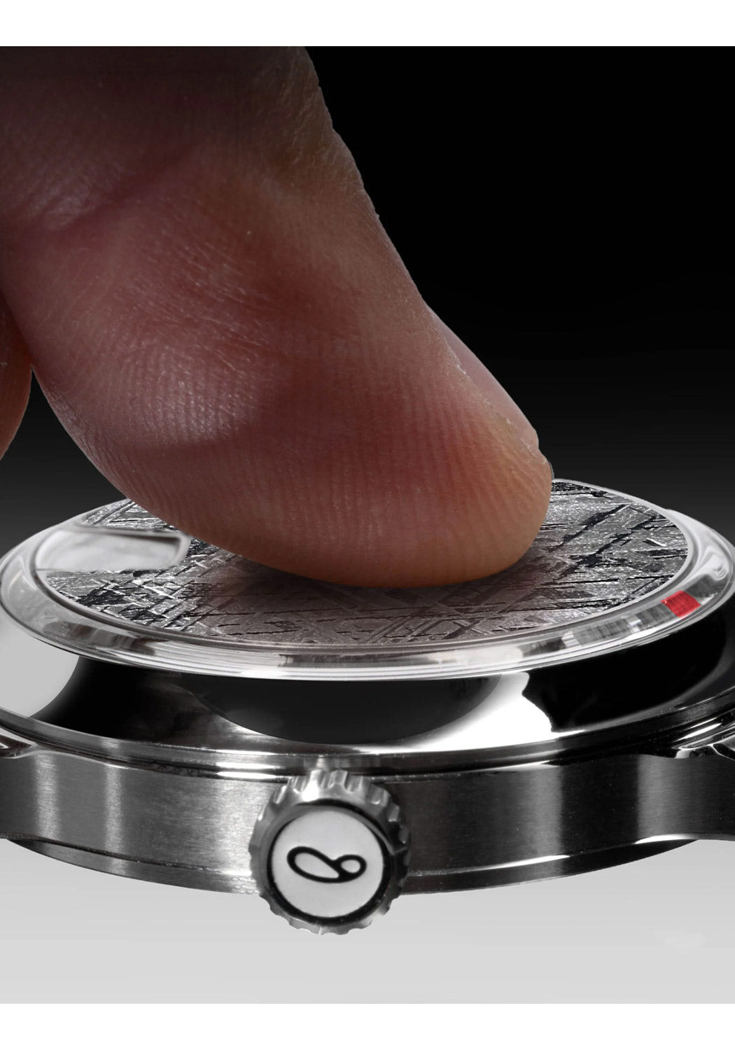 Close up of a finger touching the face of the SB 10 Jumping Hour Meteorite watch.