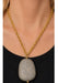 Model wearing large pavé diamond pendant on yellow gold chain.