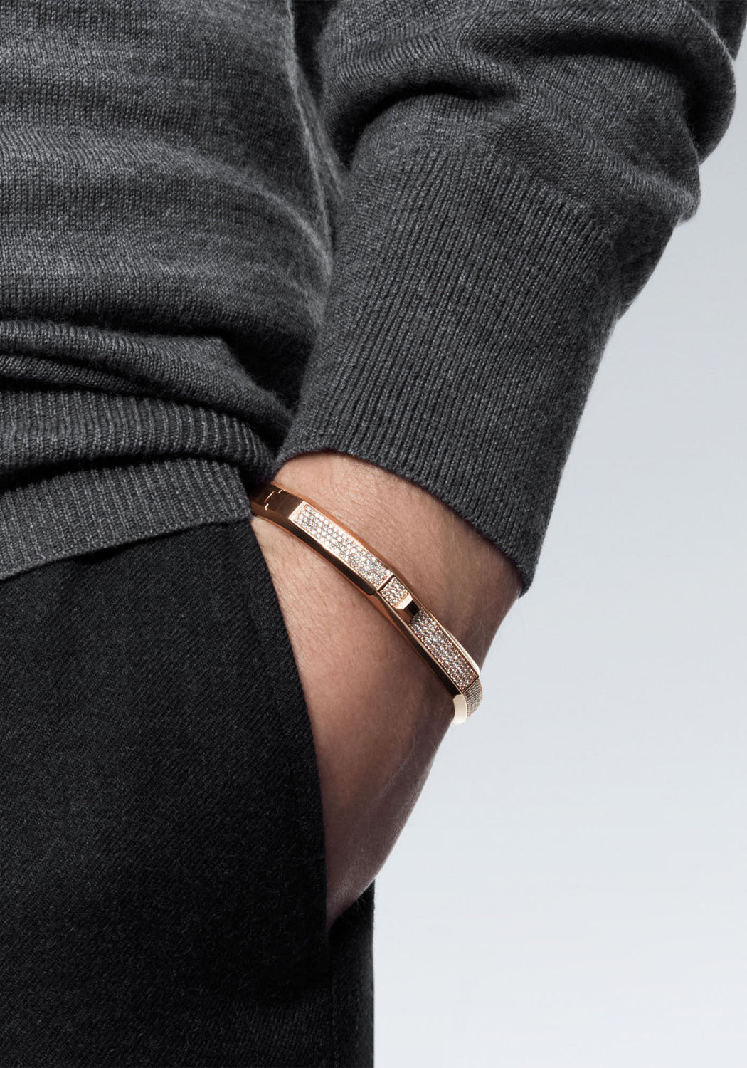 Messika Moderniste 18KRG Large Pavé Diamond Bangle on the wrist of a male model in a dark sweater