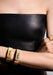 Model in a black leather top is wearing a pair of Messika Move Noa Chiseled Half Pavé Cuff Bracelets
