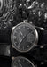 The Moritz Grossmann Benu Power Reserve Black Stainless Steel on a grey textured dial