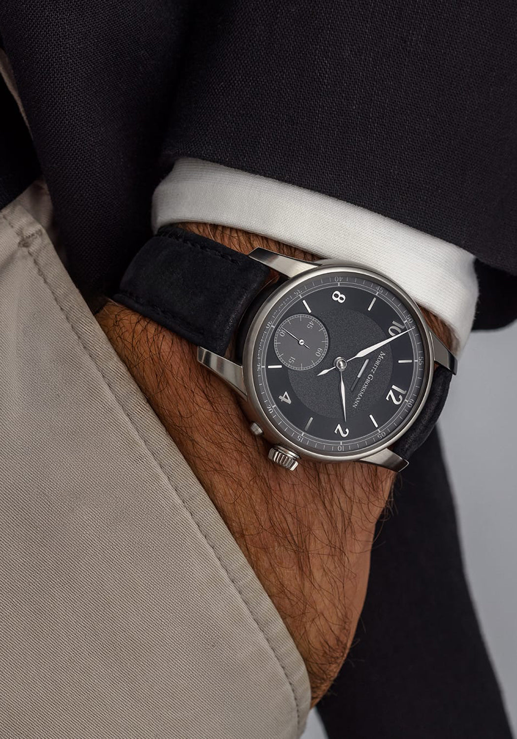 Moritz Grossmann Benu Power Reserve Black Stainless Steel on a man's wrist with hand in his pocket
