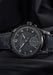 The Moritz Grossmann Benu Power Reserve Black Stainless Steel on a black background