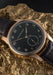 The Moritz Grossmann Hamatic Enamel Rose Gold displayed on a gold rock | OsterJewelers.com