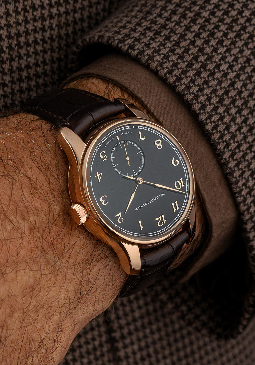 The Moritz Grossmann Hamatic Enamel Rose Gold on a man's wrist wearing a brown suit