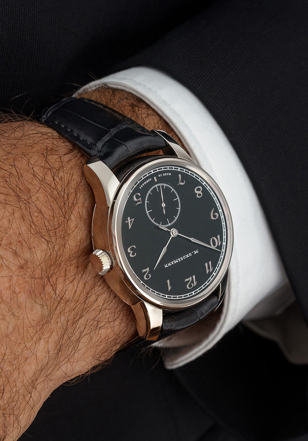 The Moritz Grossmann Hamatic Enamel White Gold on a man's wrist wearing a black suit