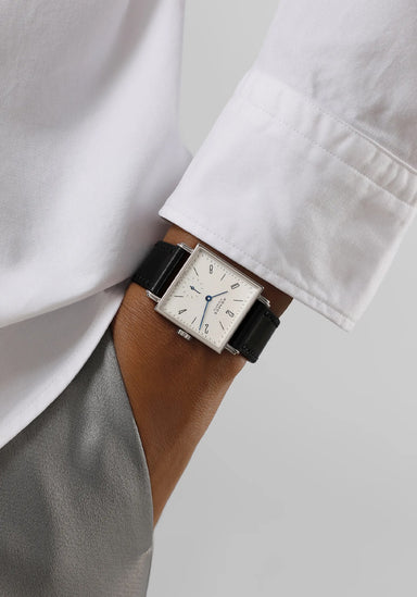 The clean white dial of the NOMOS Tetra 27 White Stainless Steel Watch pops on a man's wrist