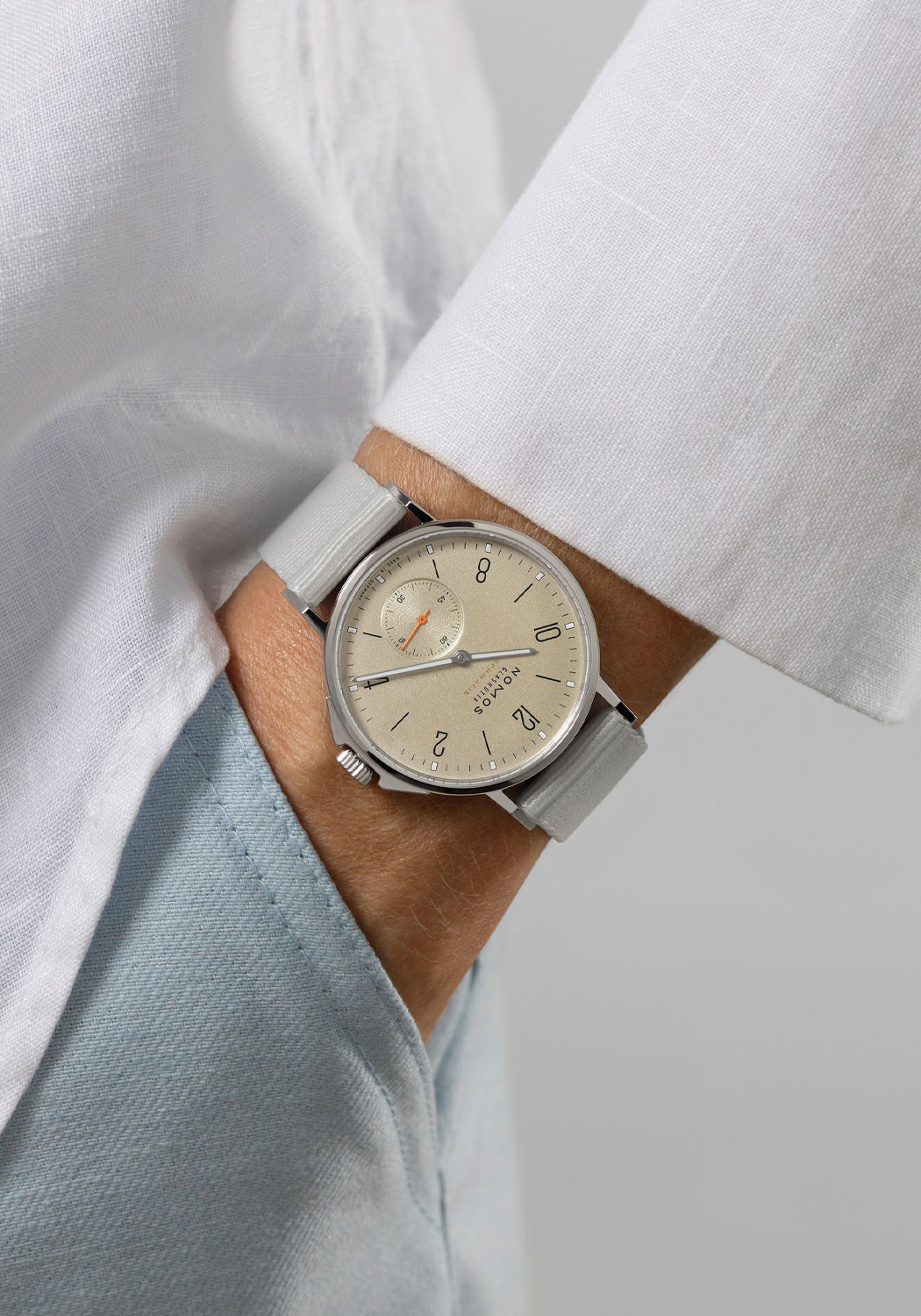 The NOMOS Ahoi Neomatik Sand features a light golden dial. Shown on a woman's wrist.