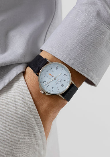 The NOMOS Ahoi Neomatik Sky features a light blue dial. Shown on a man's wrist.