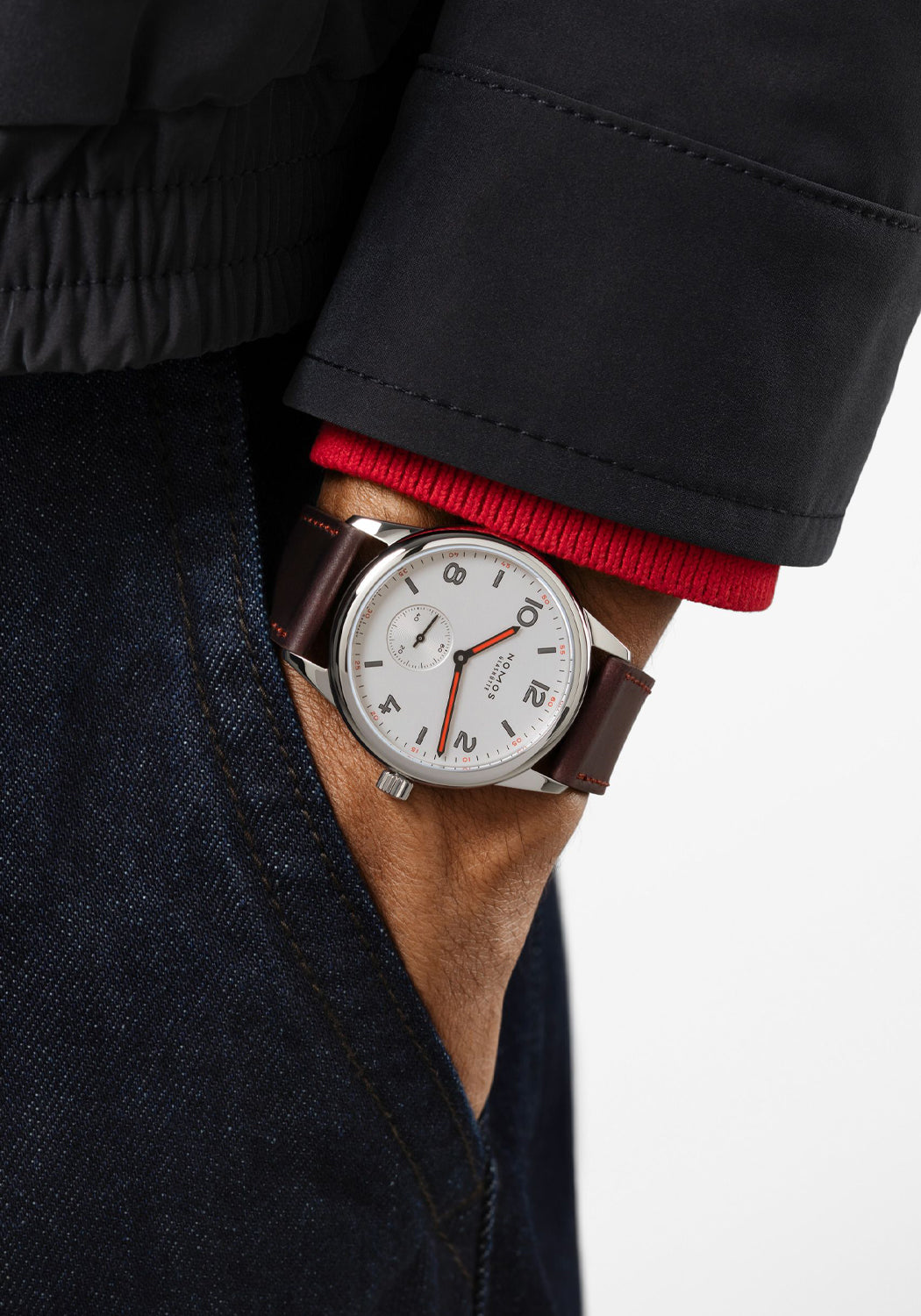 The clean dial of the NOMOS Club 38 flatters every gender. Shown on a man's wrist.