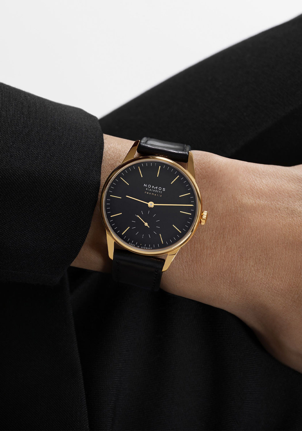 The NOMOS Orion Gold Neomatik New Black 36mm shines on the wrist with its black dial & gold accents

