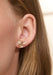 Closeup of a model wearing a single Ole Lynggaard Shooting Stars 18KYG Diamond Starburst Earring