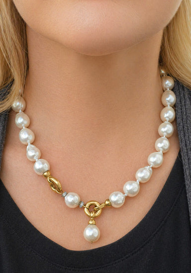 Large Pearl necklace with a gold clasp worn by blonde woman