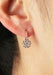 A closeup of a single Parade Design 18KRG Diamond Cluster Drop Earring on a model's ear