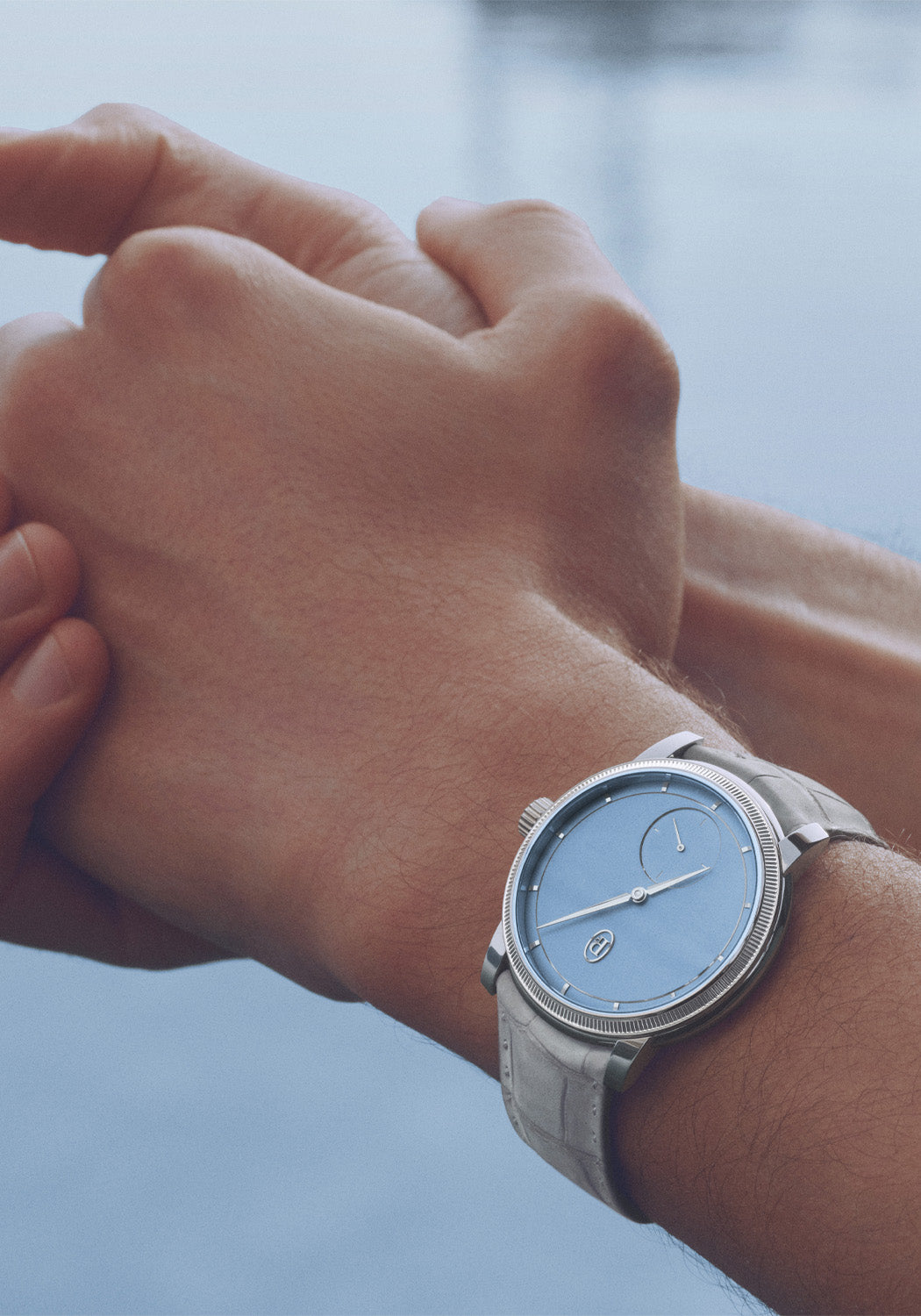 The Parmigiani Fleurier Toric Petite Seconde Morning Blue on a man's wrist shows the striking dial