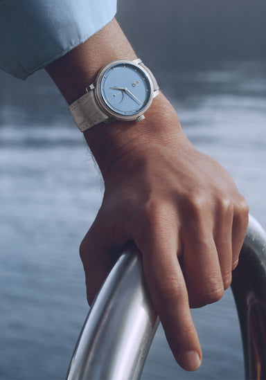 The Parmigiani Fleurier Toric Petite Seconde Morning Blue on a man's wrist by water | Denver Watches