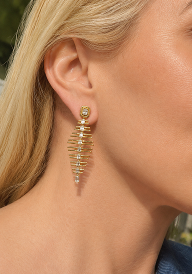 Blonde woman wearing an 18KYG fishbone earrind with diamonds down the spine.
