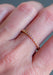 Closeup of the Sethi Couture Bezel 18KYG Mini Pink Sapphire Eternity Band on a model's hand