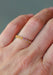The colorful Sethi Couture Bezel 18KYG Rainbow Sapphire Eternity Band worn solo on a model's hand.