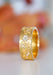 Sethi Couture Fleur 18KYG Wide Floral Diamond Band shown on its side on a blurred floral background