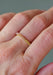 The colorful Sethi Couture Prong Rainbow Sapphire Eternity Band on a model's hand