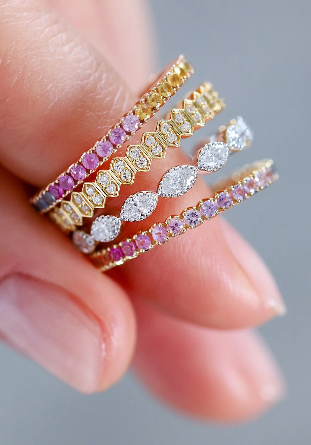 A closeup of a hand loosely wearing 4 Sethi bands towards the tip of the pointer finger.