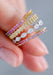 A closeup of a hand loosely wearing 4 Sethi bands towards the tip of the pointer finger.