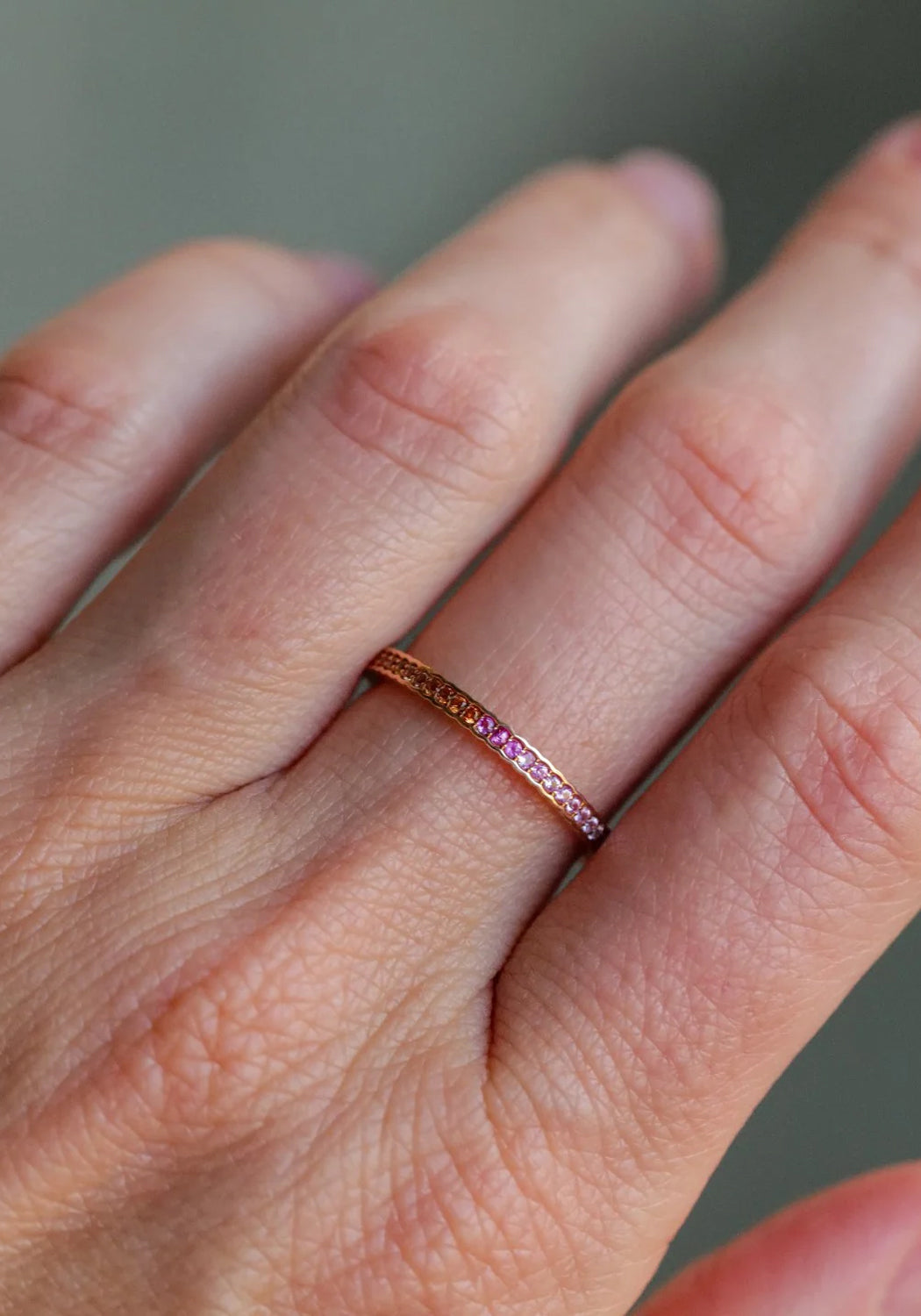 Sethi Couture Scallop 18KYG Pink Sapphire Eternity Band shows a delicate pop of color on a hand.
