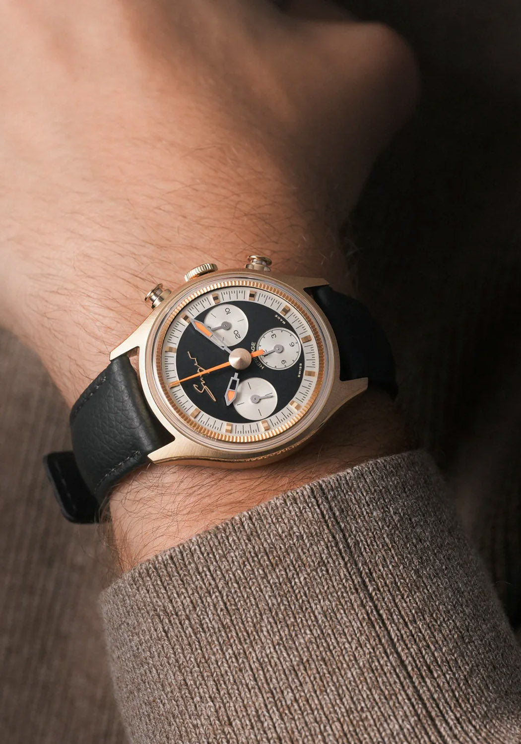 The Singer Reimagined Heritage V72 Gold on a man's wrist. It features a black grained leather strap.