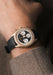 The Singer Reimagined Heritage V72 Gold on a man's wrist. It features a black grained leather strap.