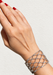 Wide "fish net" diamond bracelet on woman's wrist. Osterjewelers.com