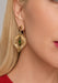 Blonde woman wearing large gold and white Victor Velyan Chrome Diopside & Pink Sapphire Dangle Earring from Osterjewelers.com