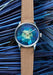 Louis Erard Marqueterie de Paille shown against the blue straw used in crafting the marquetry dial.